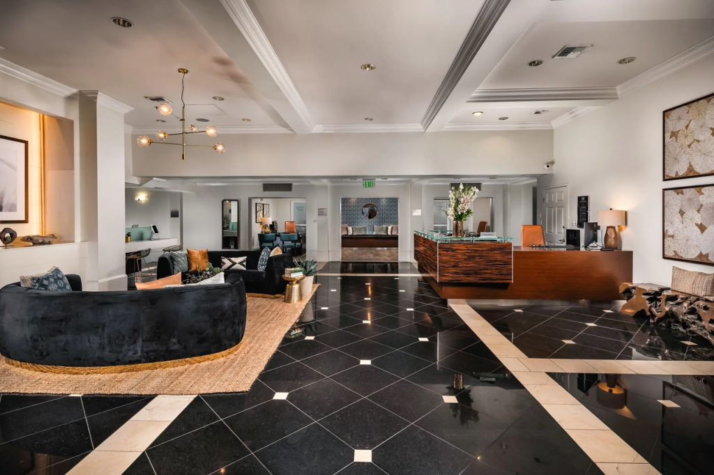 Elegant resident lounge at The Legacy at Westwood in Los Angeles, offered by Los Angeles Luxury Furnished Housing with modern seating, TV, and work-friendly space.